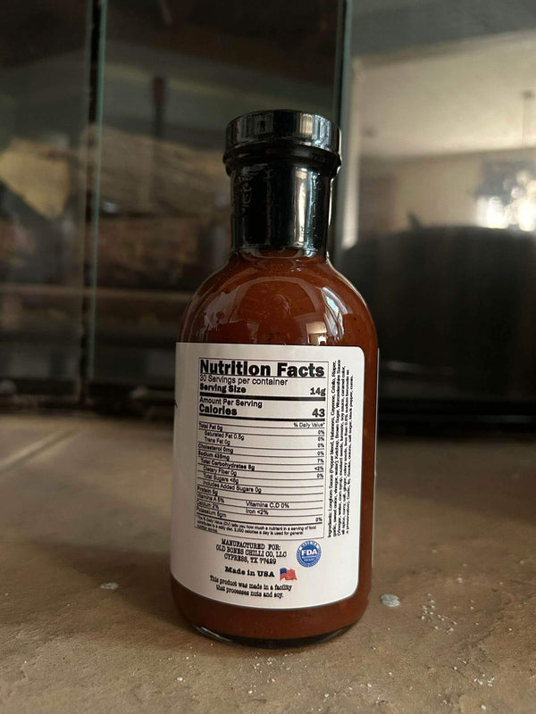 Bushwacker- 359mL(12 oz) gourmet hot sauce nutrition facts label on a dark background.